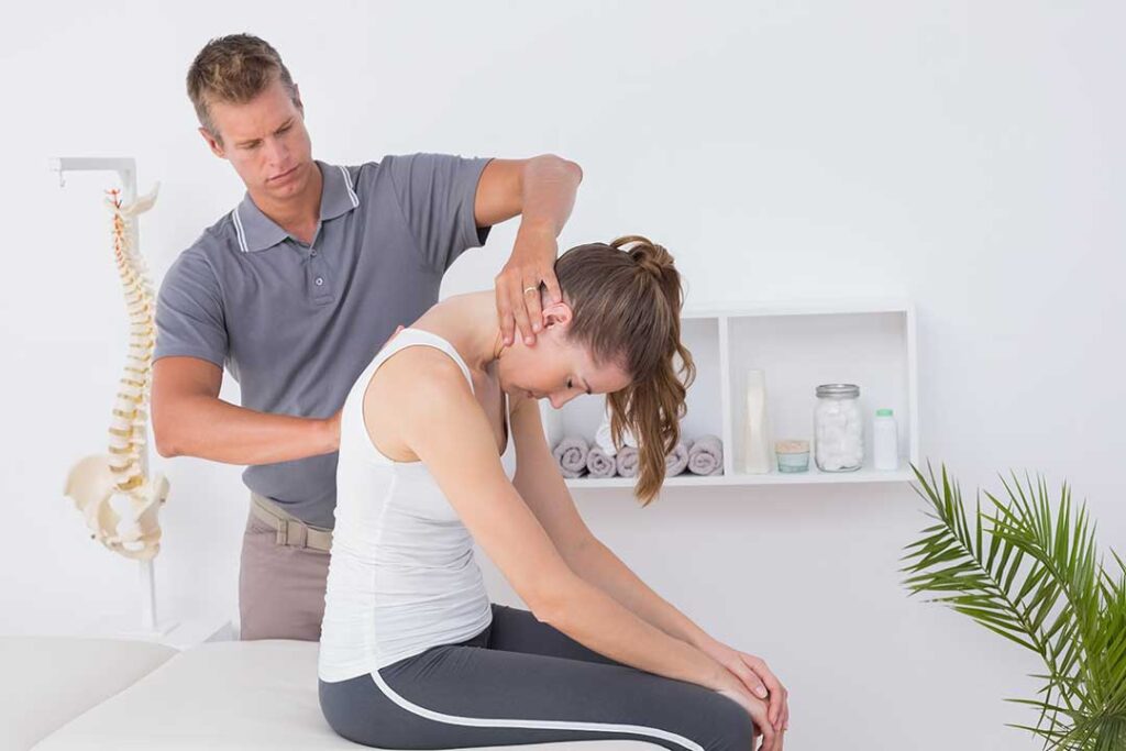 Older adult practicing balance beside a sturdy chair in a bright home exercise area.